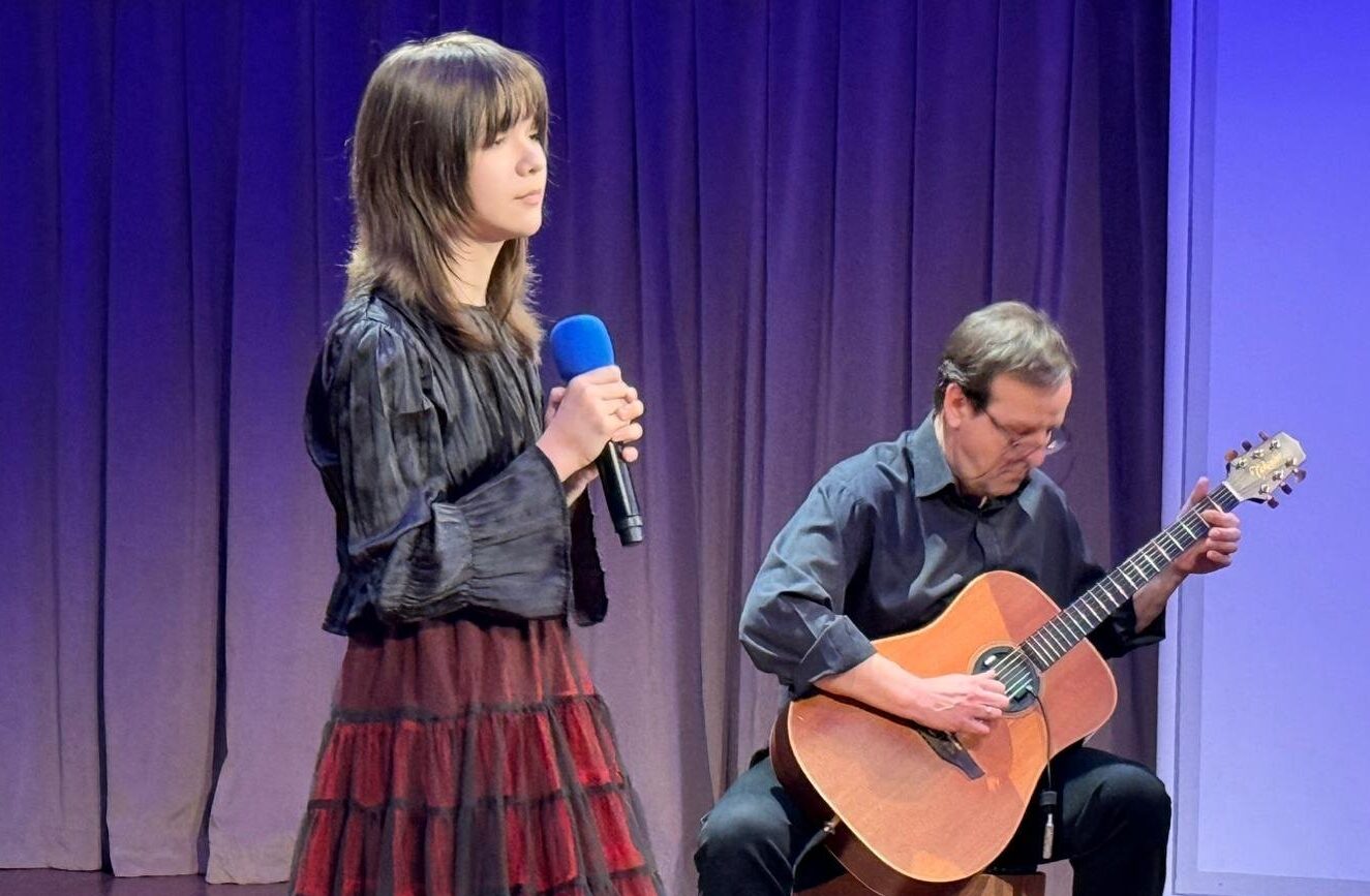 dziewczyna z mikrofonem i mężczyzna grający na gitarze