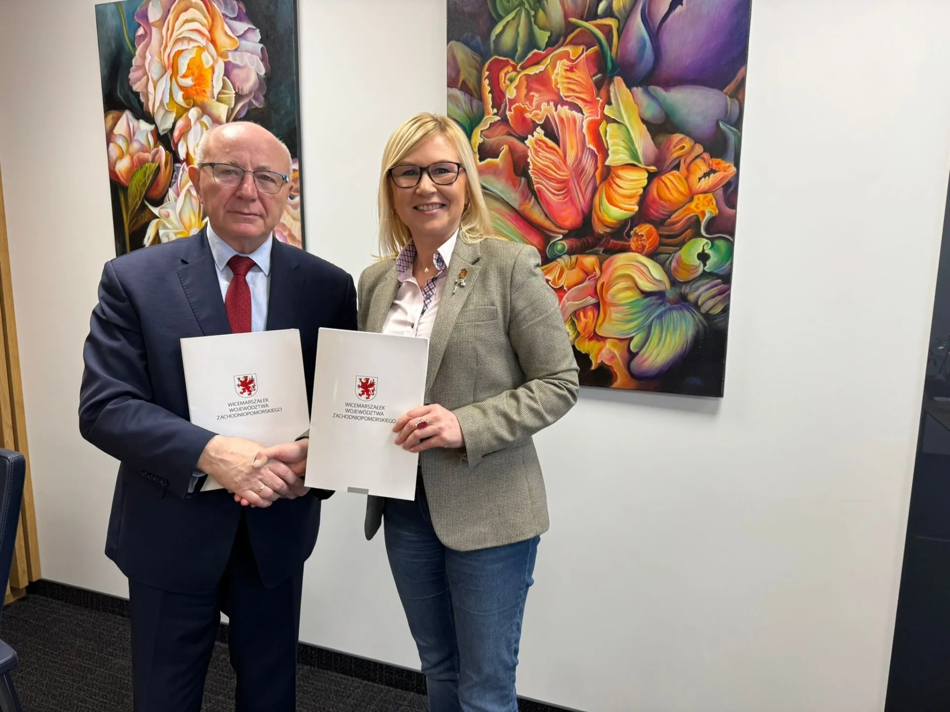 Sygnatariusze porozumienia prezentują podpisaną umowę.