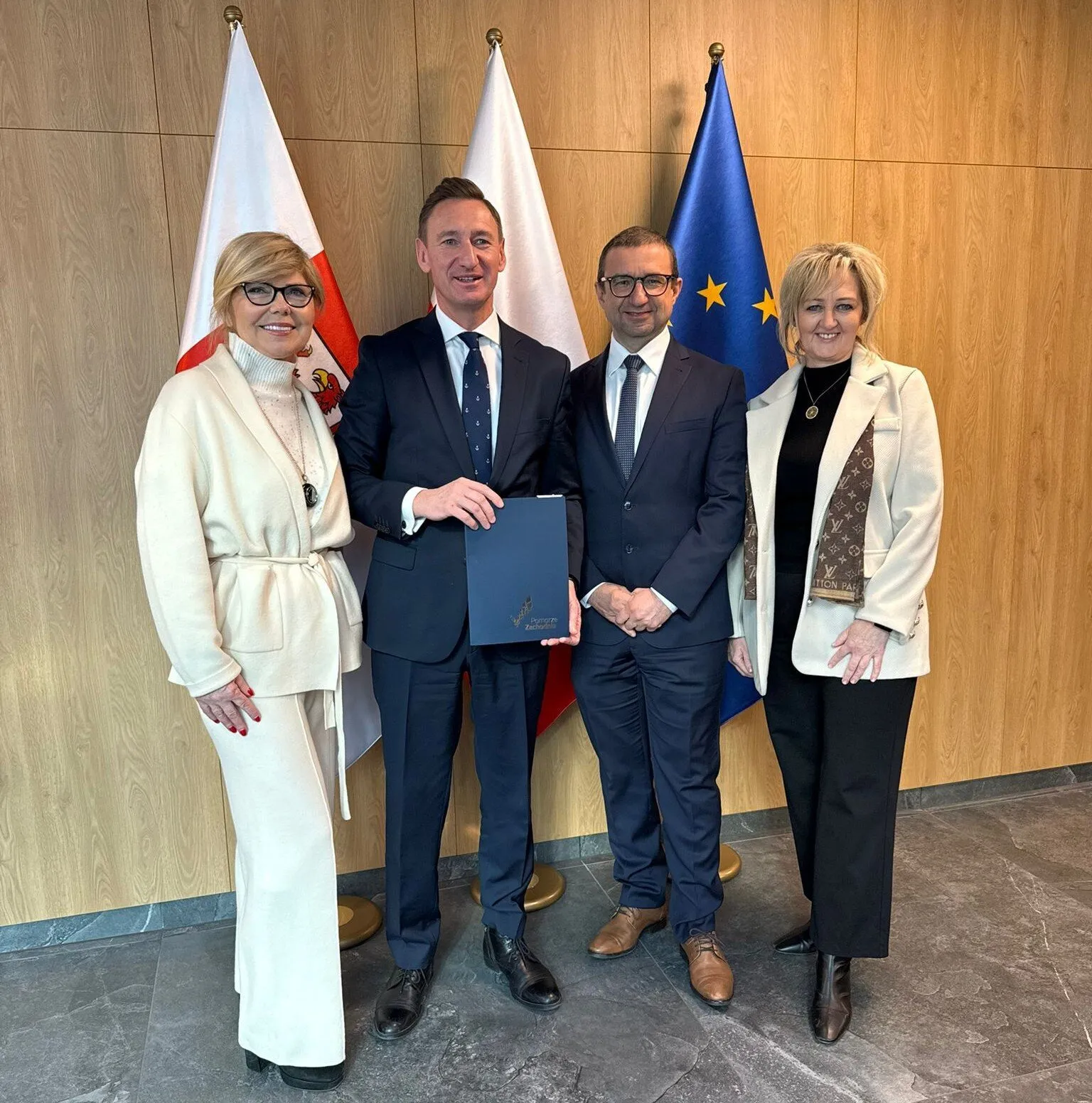 Sygnatariusze umowy prezentują podpisane porozumienie.