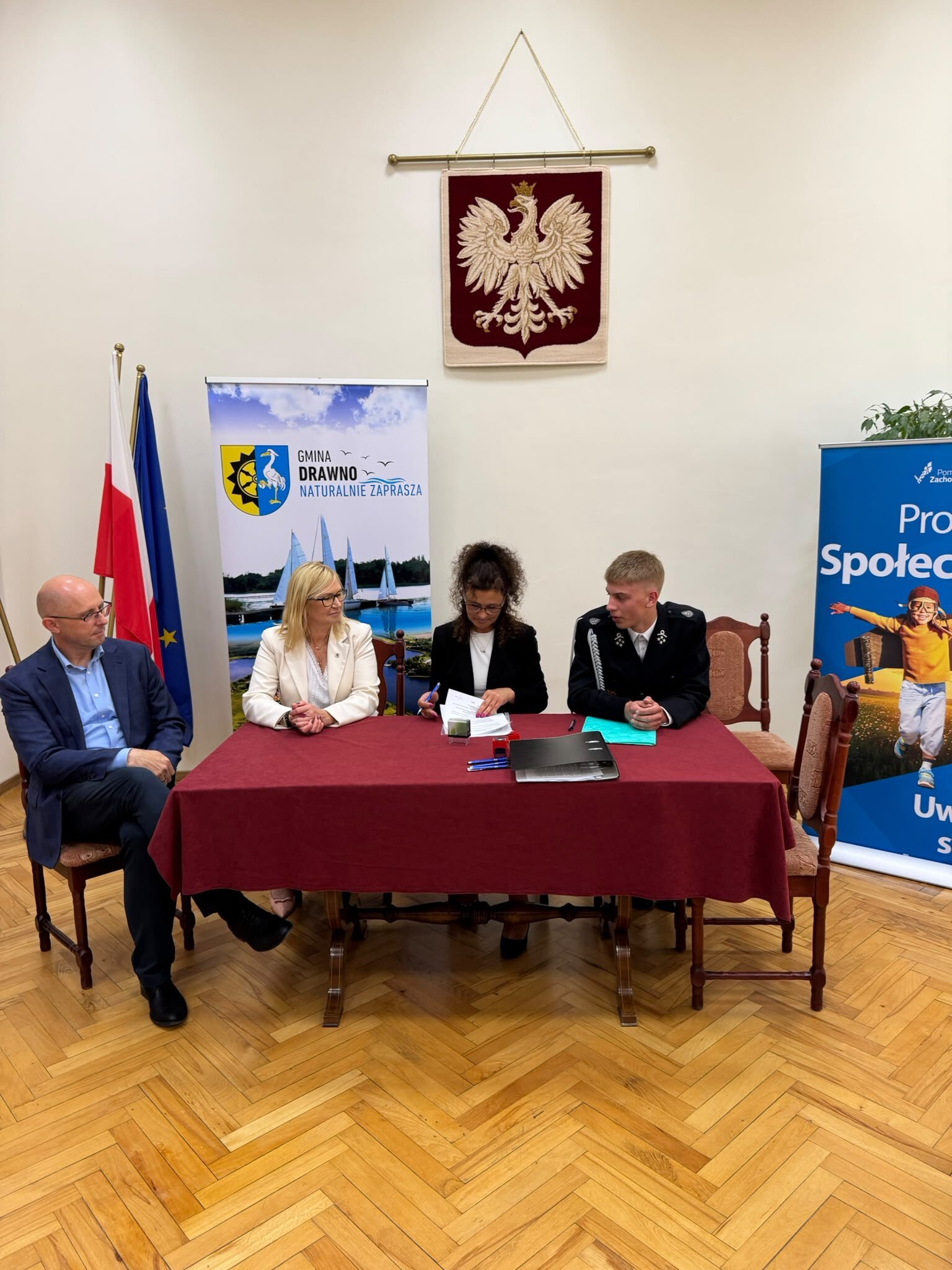 sala konferencyjna i podpisanie umowy przez Społecznika, za stołem w środku Natalia Wegner, po lewej wicemarszałek Anna Bańkowska