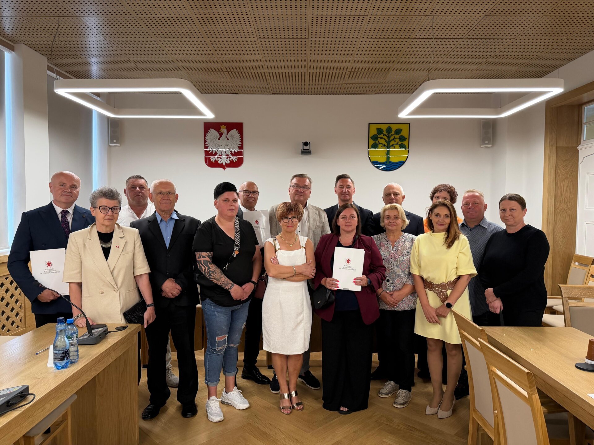 Sygnatariusze umów prezentują na wspólnym zdjęciu podpisane porozumienia.