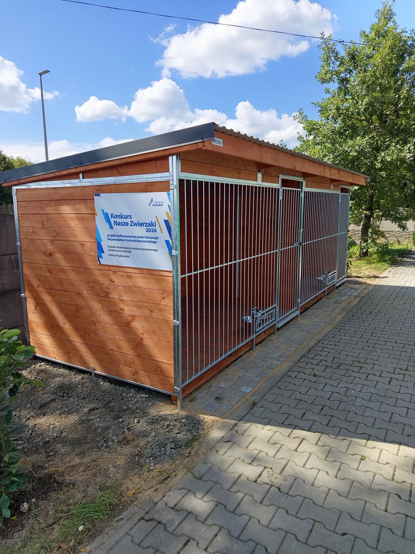 boks dla psów drewniany wraz z tabliczką z informacją o dofinansowaniu projektu ze środków Województwa Zachodniopomorskiego