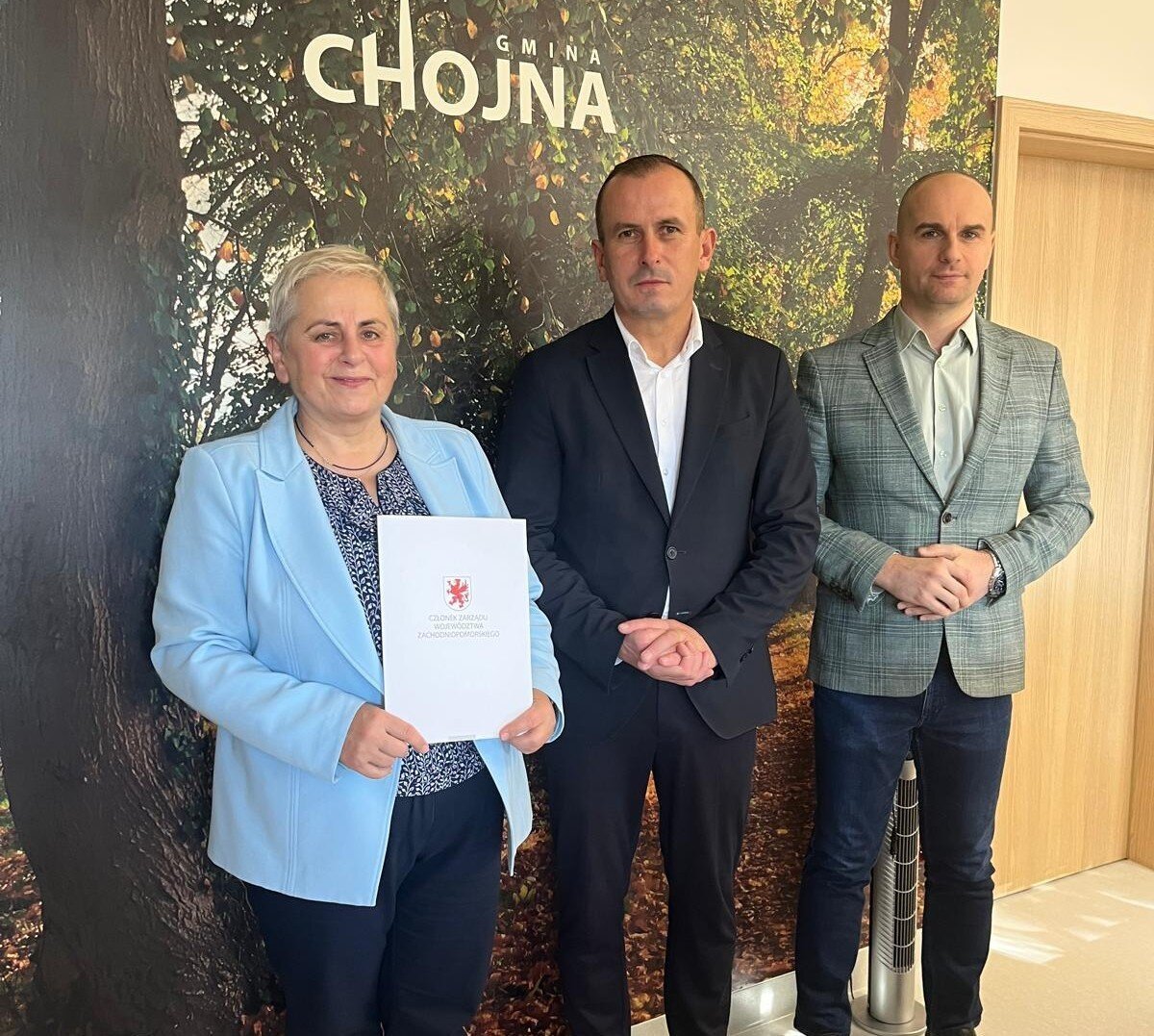 Strony prezentują podpisane porozumienie, w tle ścianka z napisem Chojna.