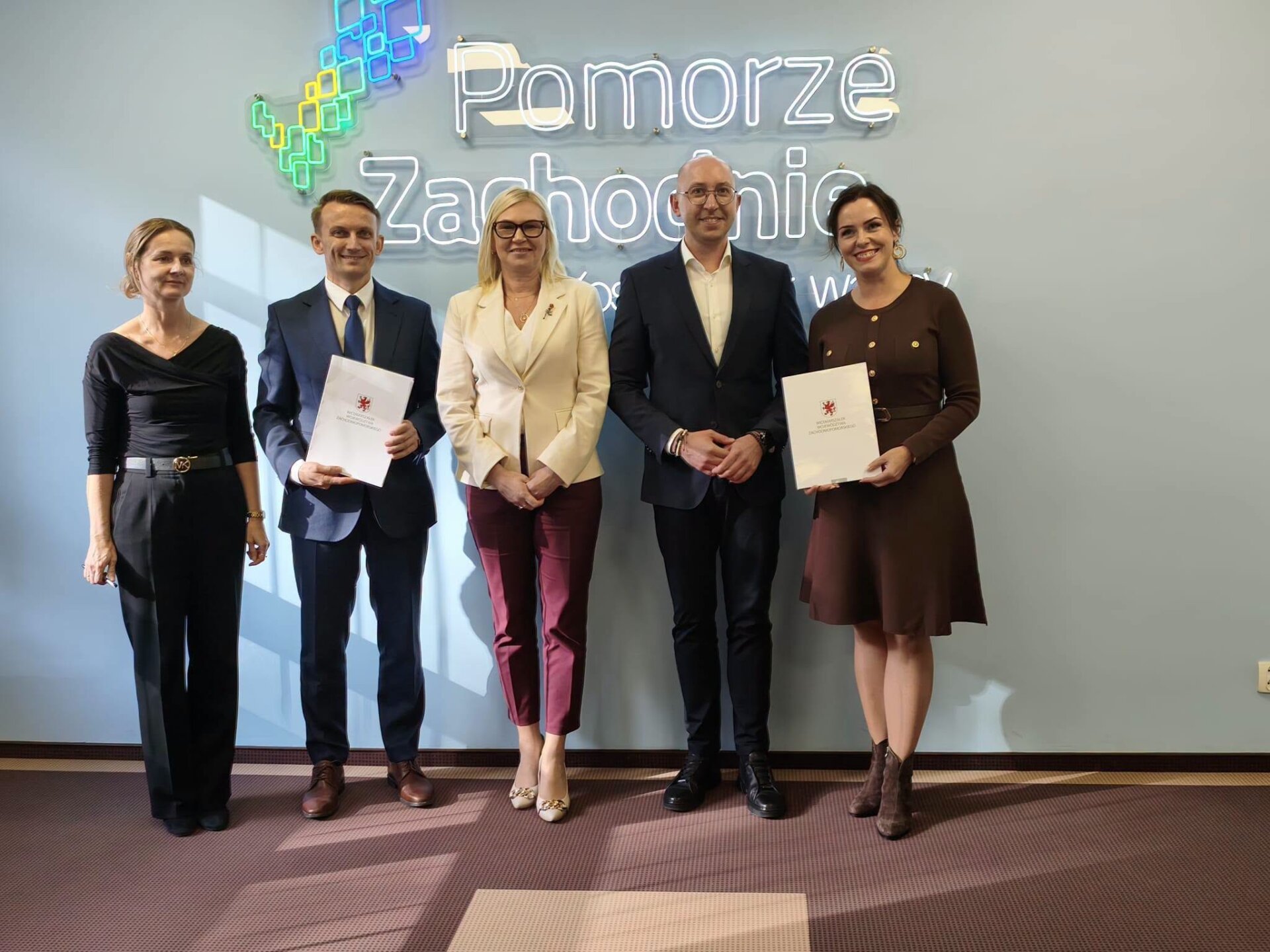 wspólne zdjęcie po podpisaniu umowy na tle napisu Pomorze Zachodnie